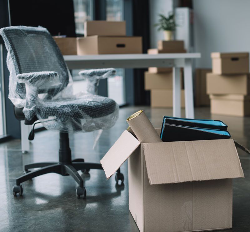 Bureaux d'entreprise avec des cartons et chaise emballée