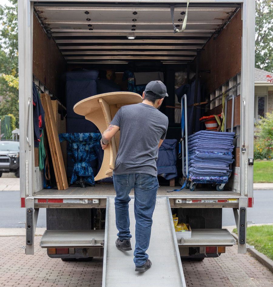 Déménageur amenant une table dans un camion de déménagement