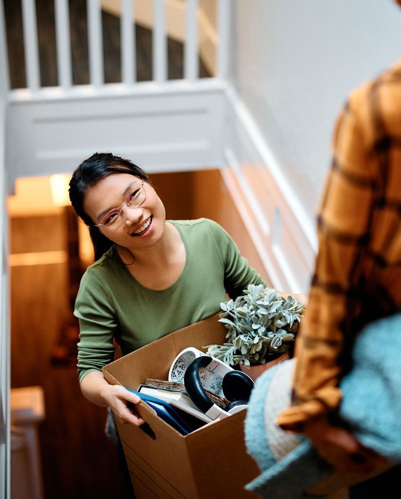 Jeune femme portant un carton avec des affaires personnelles