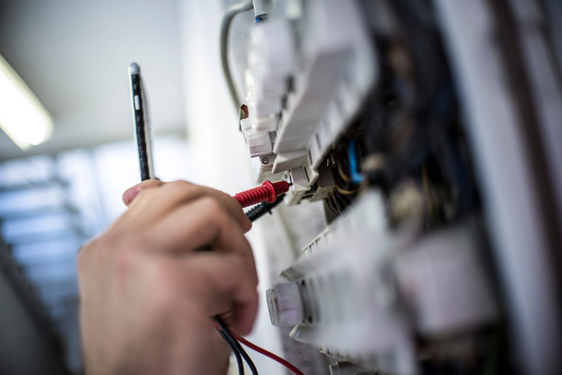 Una persona está usando un multímetro para probar un circuito eléctrico.