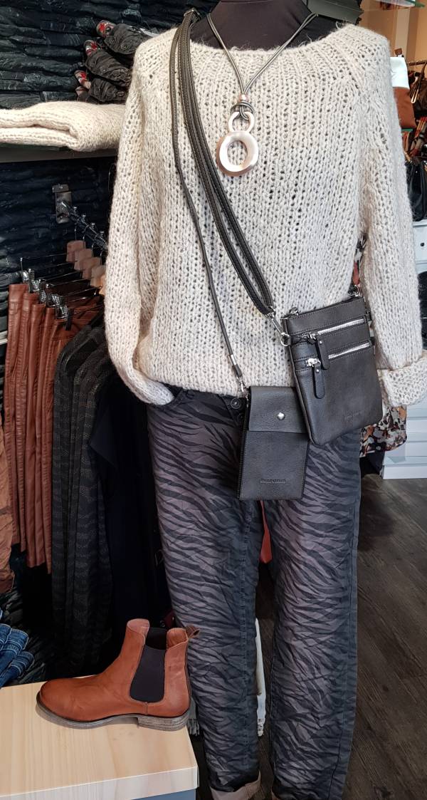 Modepuppe trägt Strickpullover und dunkle Zebrajeans