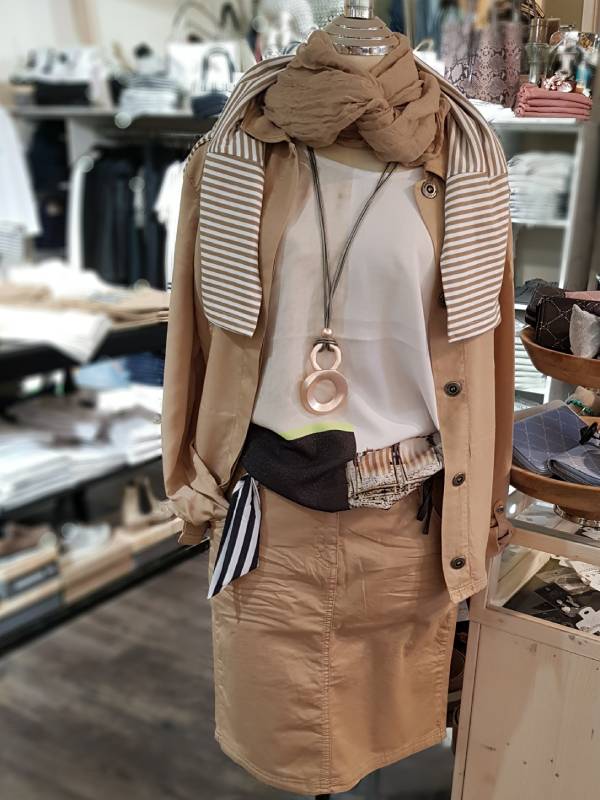 Modepuppe trägt Kleidungsensemble in braun & beige
