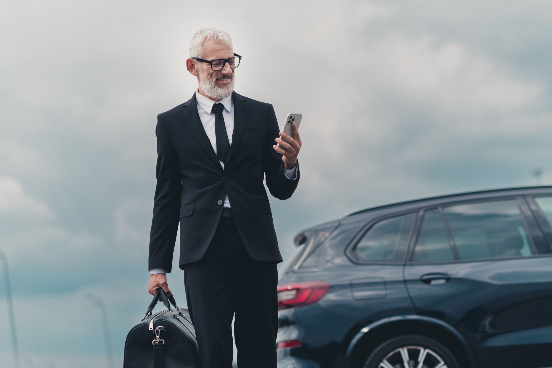 Un homme en costume avec un sac et un téléphone à la main.