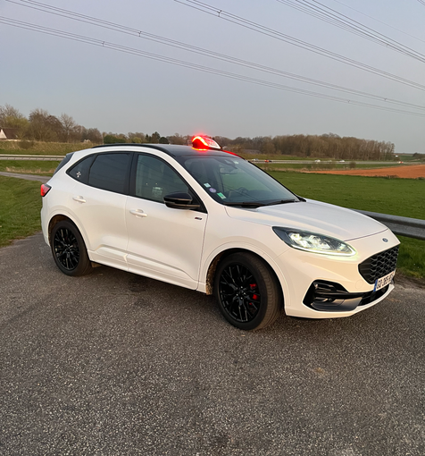 Une voiture blanche vue du côté droit.