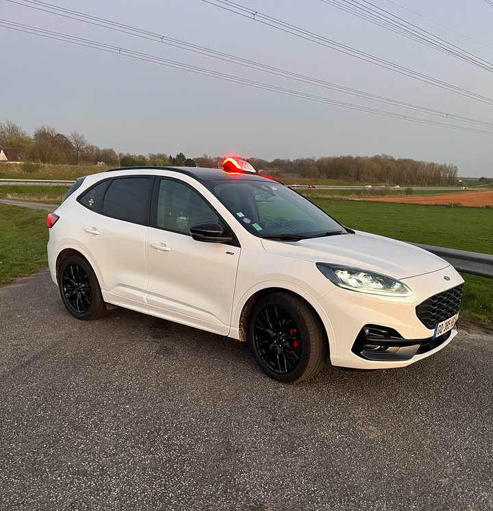 Une voiture de taxi blanche avec un lumineux dessus.