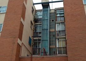 Un edificio de ladrillo con un ascensor de cristal en el medio.