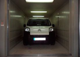 Una furgoneta blanca está estacionada en un ascensor.