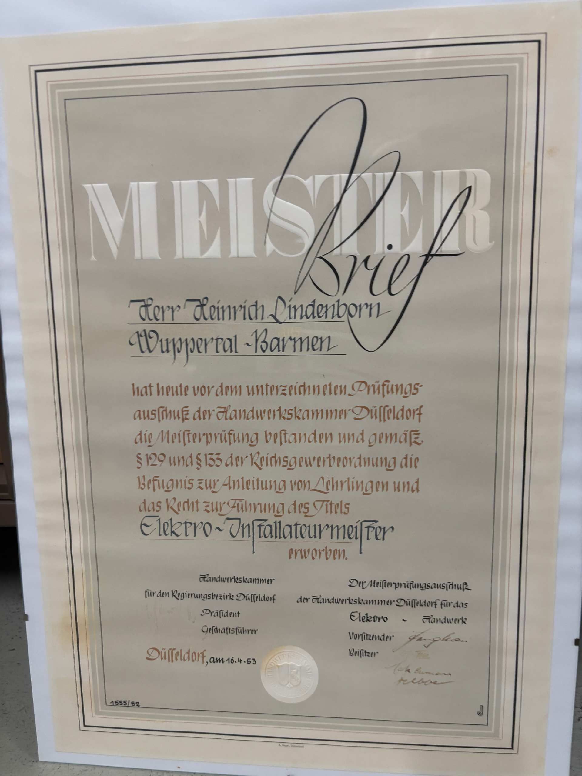 Gerahmte beige Auszeichnungsurkunde mit kunstvoller Schrift und großer Überschrift „MEISTERBrief“.