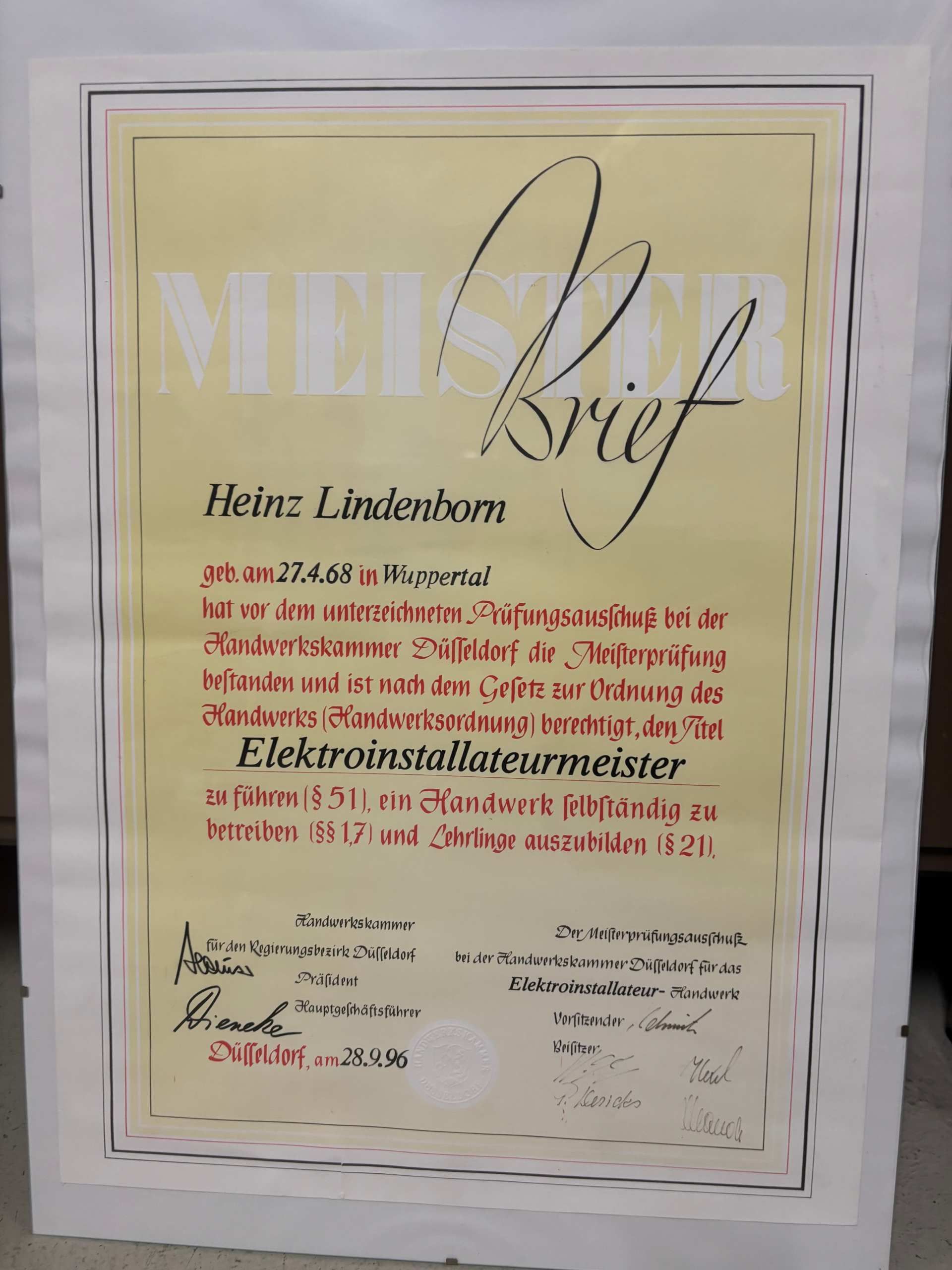 Gerahmte Urkunde mit deutschem Text auf hellgelbem Hintergrund, signiert von Heinz Lindenboom.