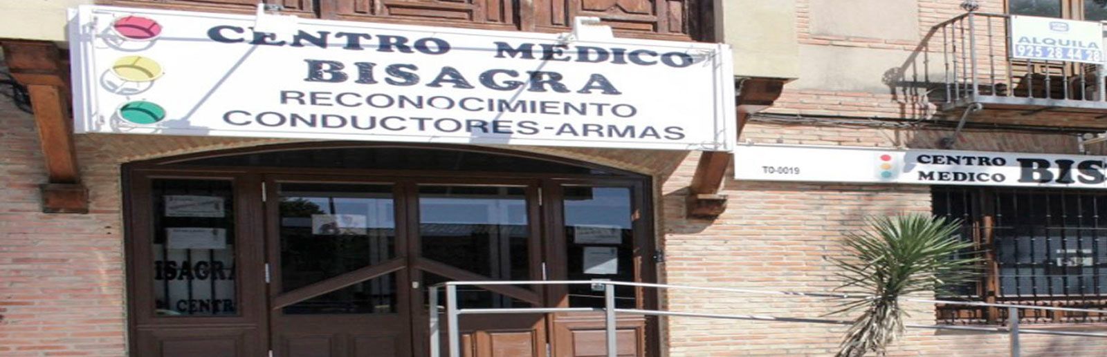 Entrada del Centro Médico Jeságua, un letrero de una clínica médica sobre una puerta, con una fachada de local comercial y ventanas
