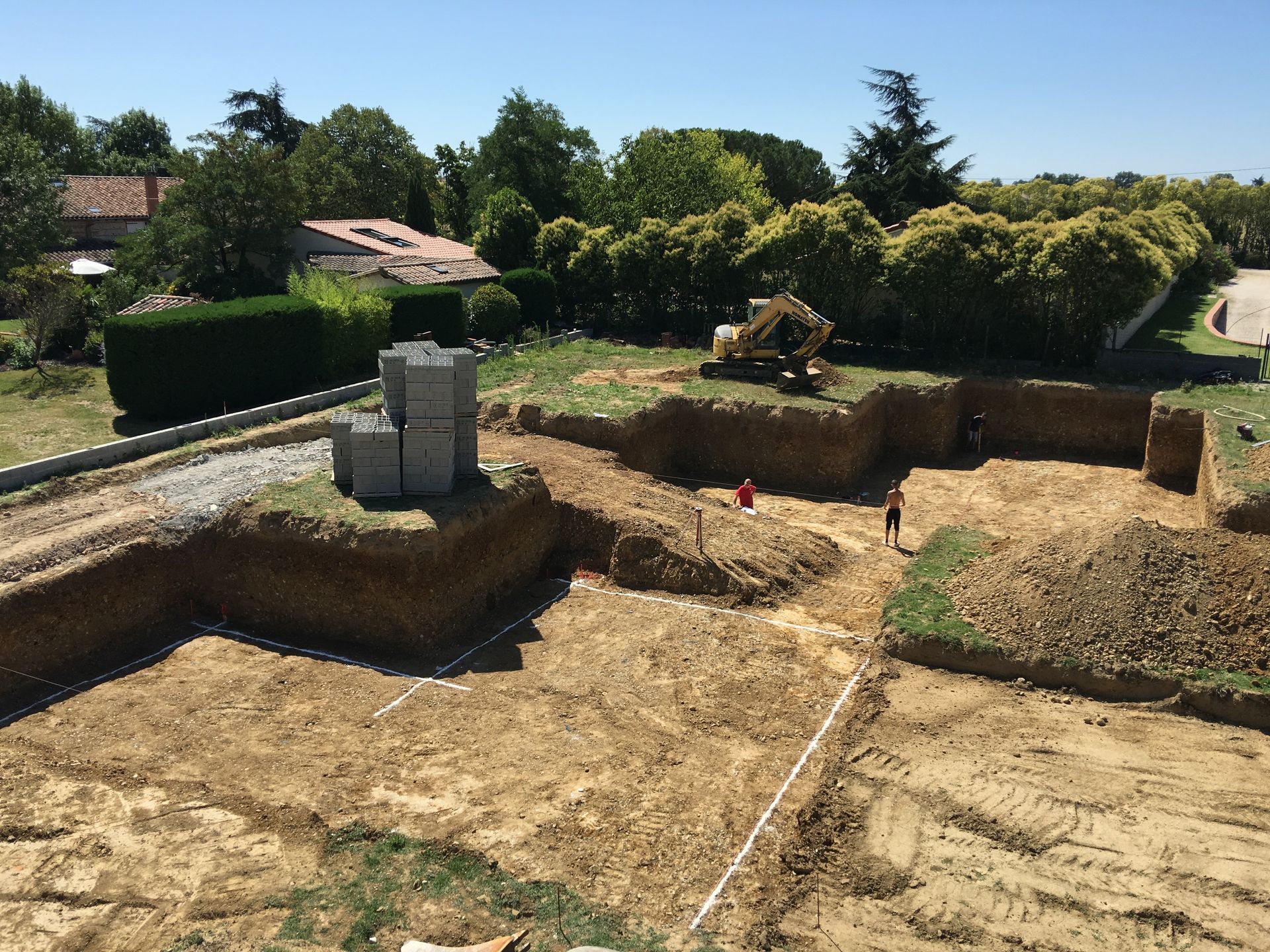 Une pelleteuse mécanique garée sur l'herbe à côté d'un grand trou