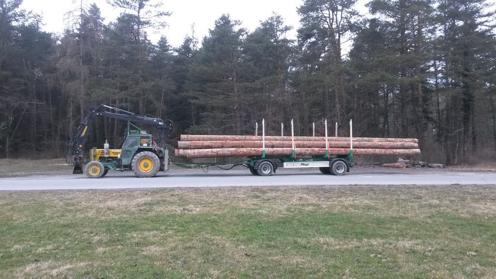 Lange Baumstämme auf Traktor – Andi Caviezel Holztransporte