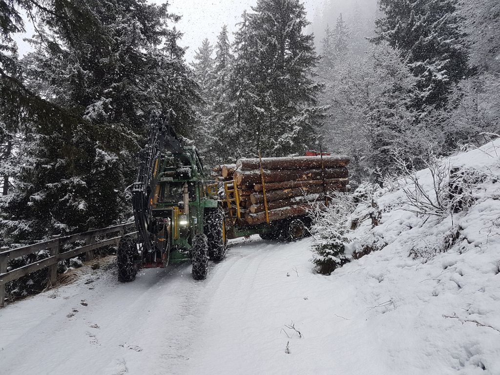 Traktor mit Anhänger Winter –  Andi Caviezel Holztransporte