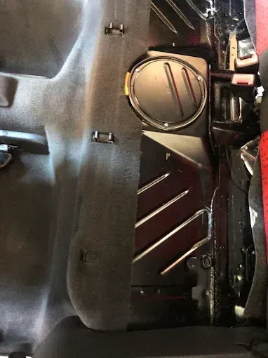 Primer plano del interior del coche, donde se aprecian el panel de una puerta y el compartimento lateral de almacenamiento 