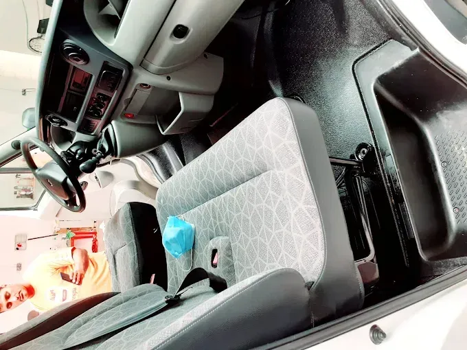 Interior del coche con asientos y salpicadero de tela gris estampada, y el asiento del pasajero tapizado en tela azul.