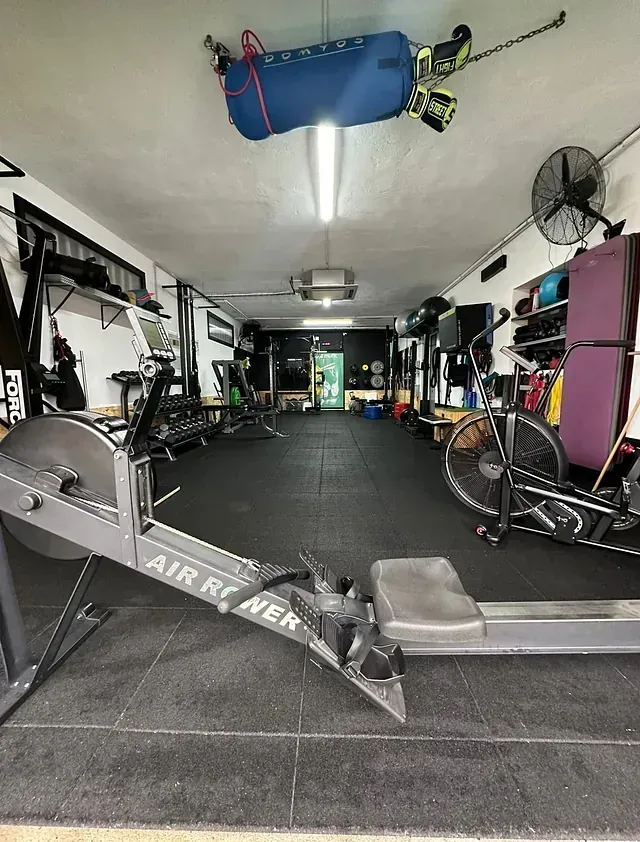 Hay una máquina de remo en el medio de un gimnasio.