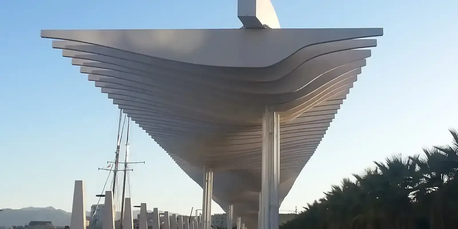 Una estructura blanca muy larga con un cielo azul de fondo.