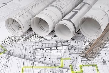 Varios rollos de planos están colocados uno encima del otro