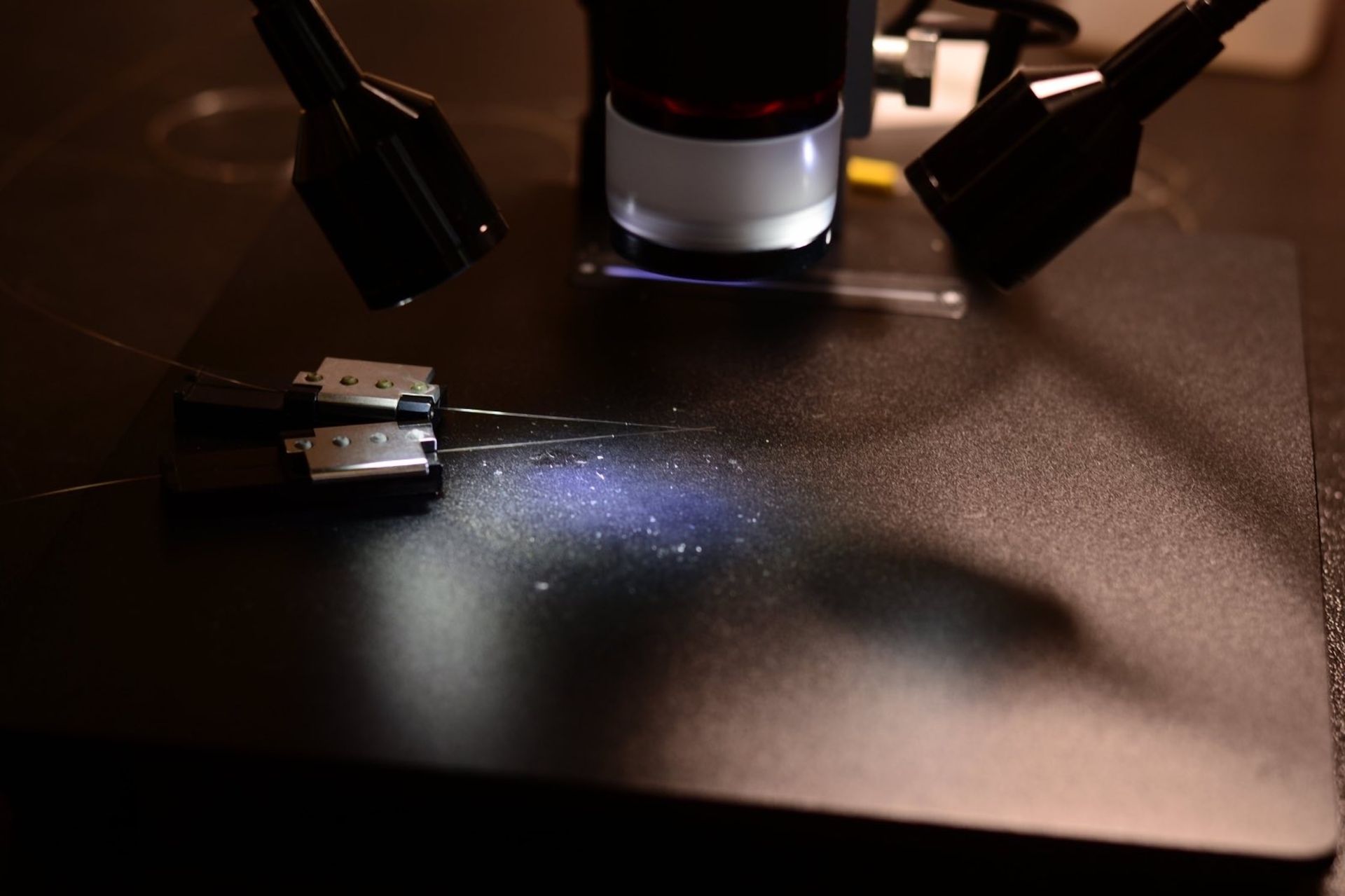 Un microscopio está situado encima de una superficie negra.