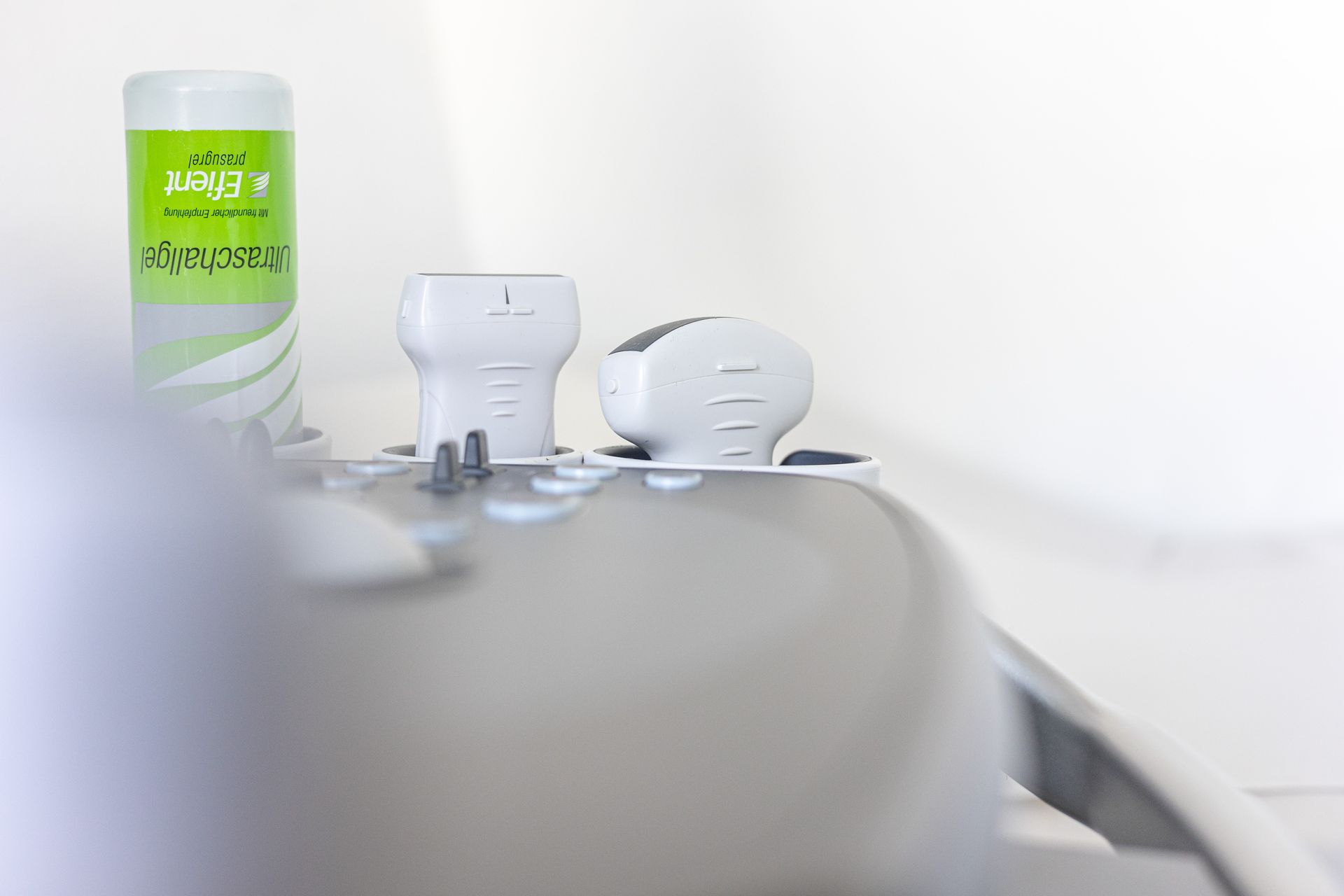 Nahaufnahme eines Ultraschallgeräts mit Sonden und Reinigungslösung. Weißer Hintergrund.