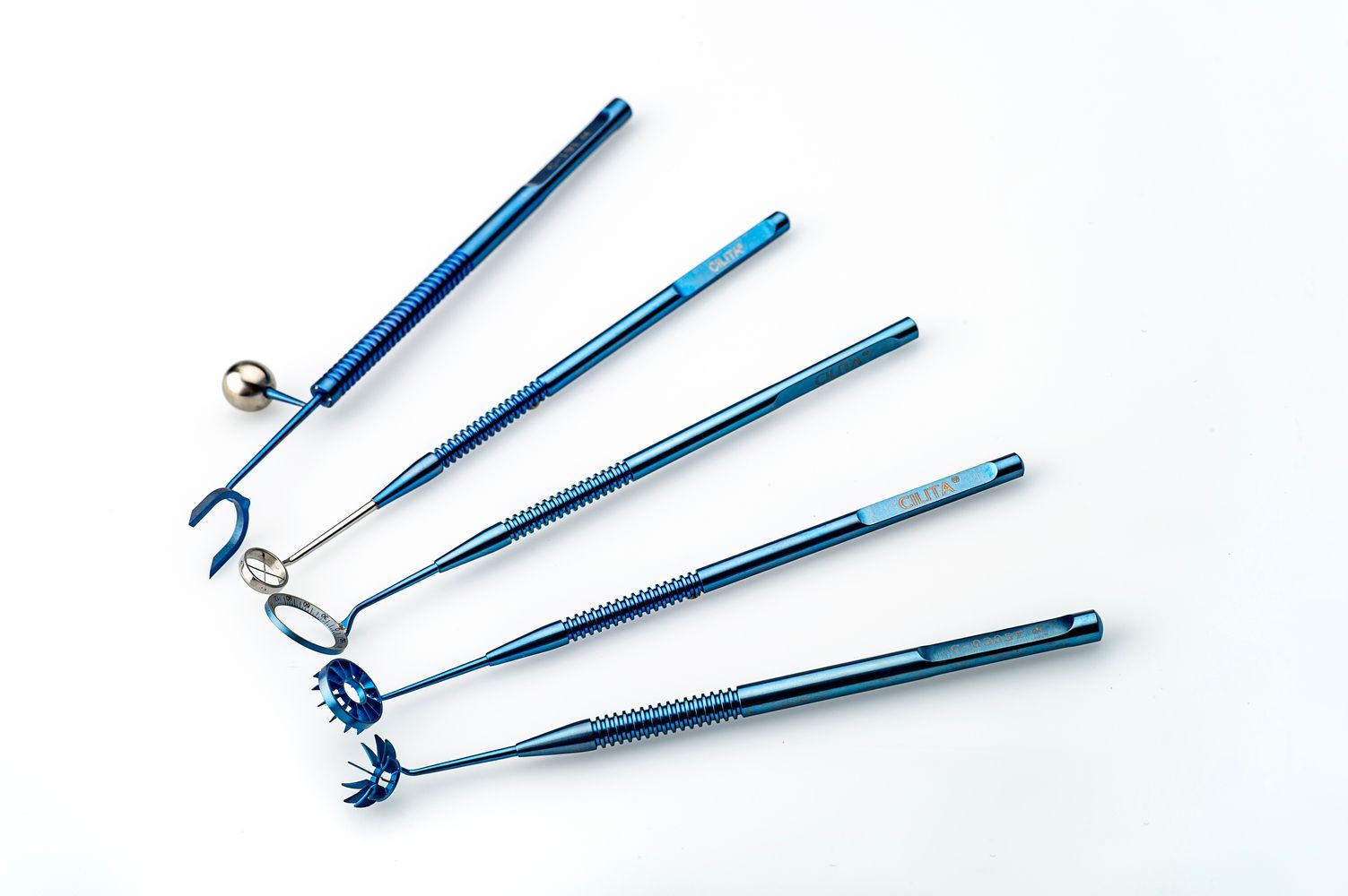 Un conjunto de instrumentos quirúrgicos azules sobre una superficie blanca.