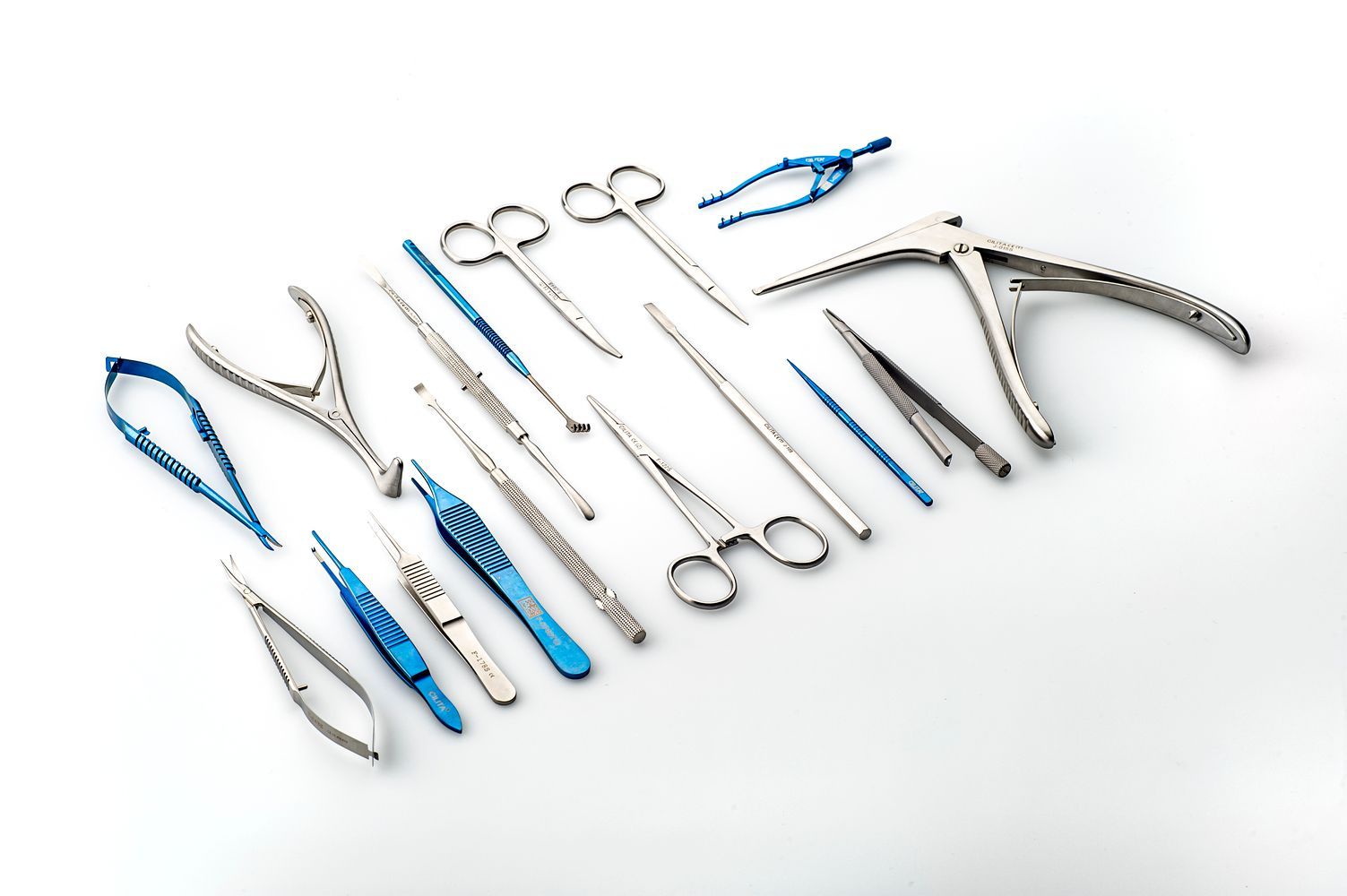 Un montón de instrumentos quirúrgicos están alineados sobre una superficie blanca.