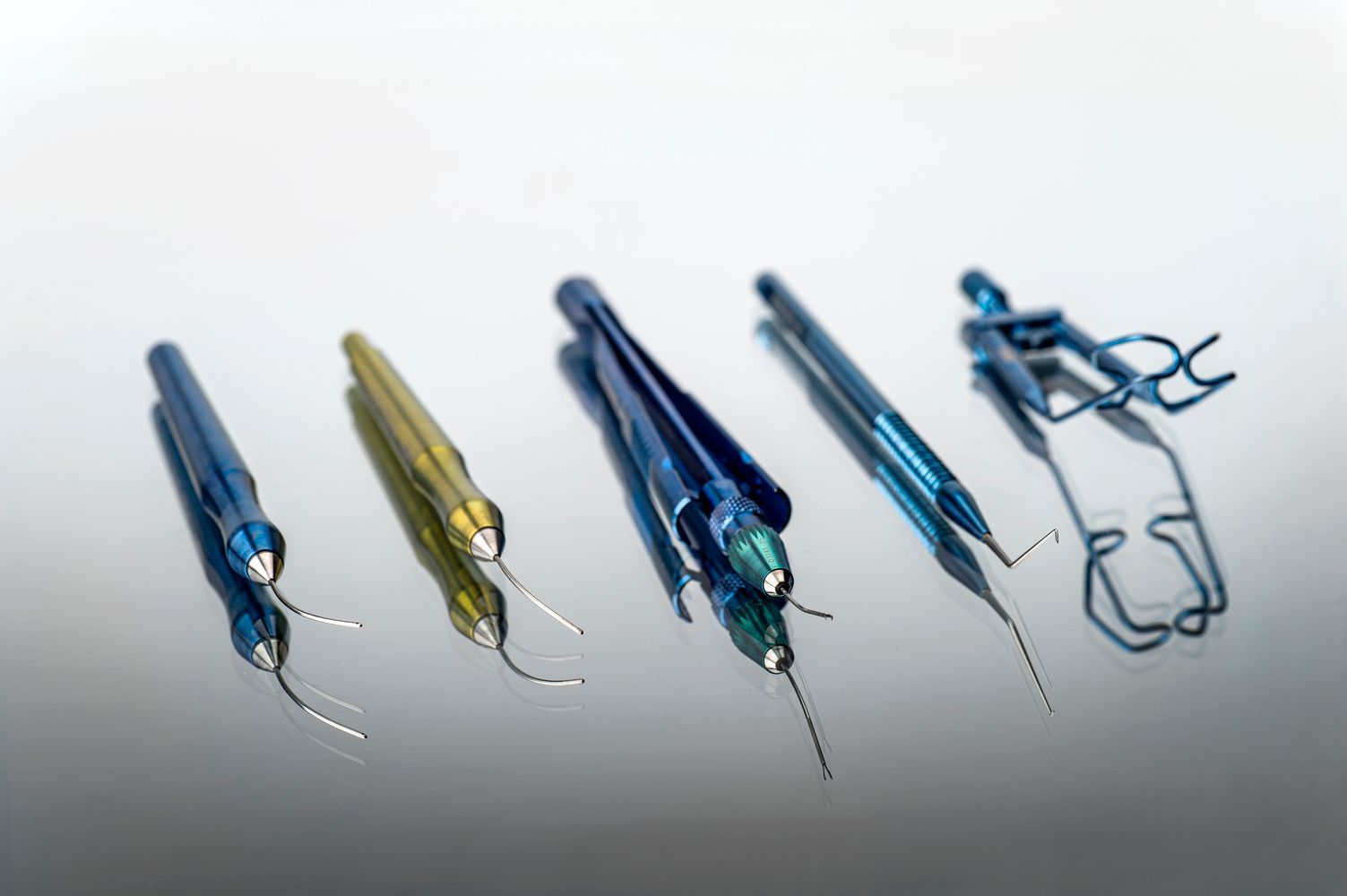 Una fila de instrumentos dentales están alineados sobre una mesa.