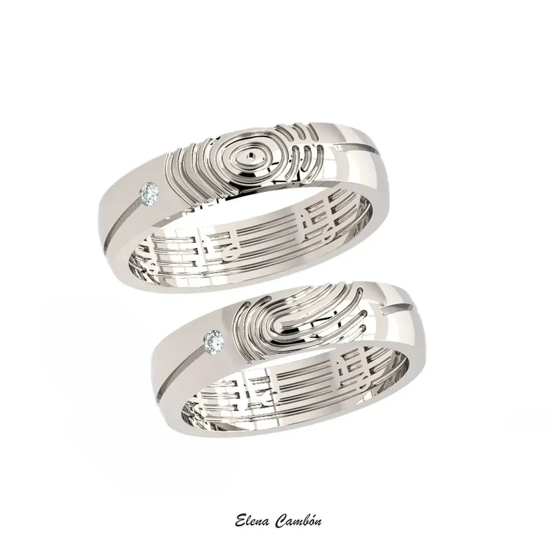 Dos anillos plateados con diseño apilados sobre un fondo blanco.