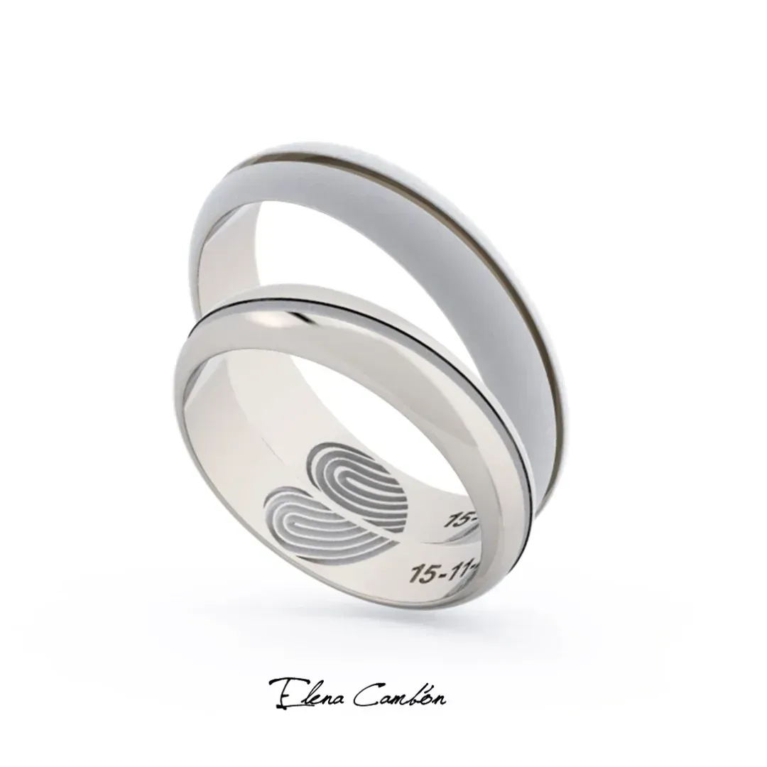 Dos anillos entrelazados de plata con una incrustación blanca brillante sobre un fondo blanco.