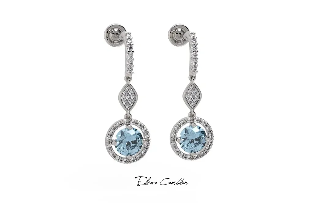 Par de pendientes colgantes de plata con piedras preciosas azules y piedras transparentes sobre fondo blanco.