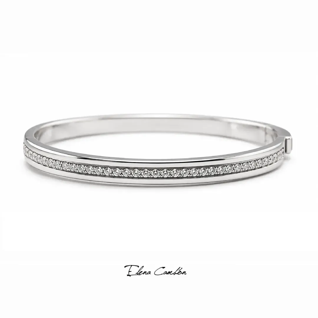 Pulsera delgada de plata con diamantes pavé sobre fondo blanco.