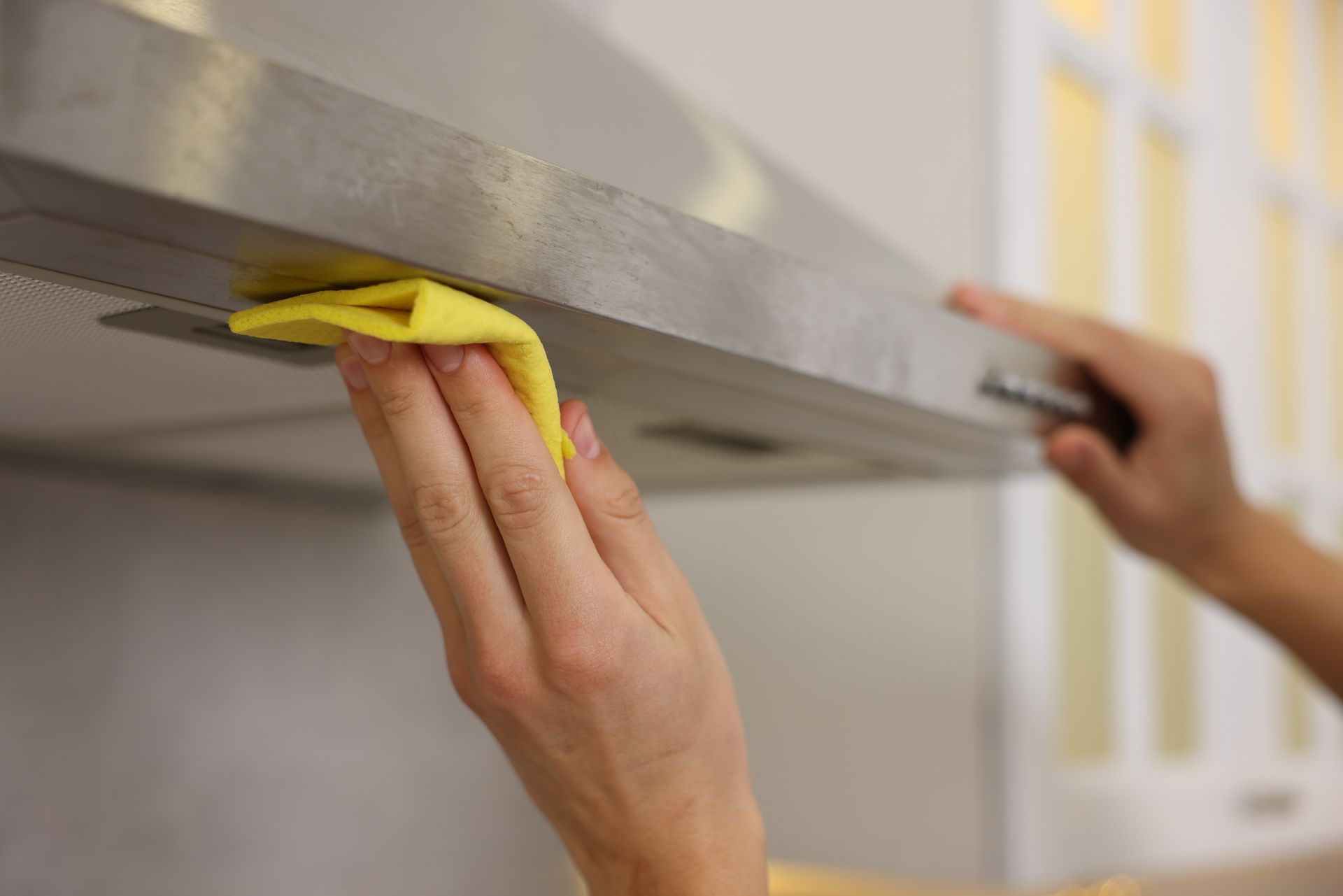 Nettoyage d'une hotte avec un chiffon jaune