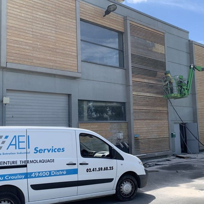 Camion d'AEI Services devant un bâtiment