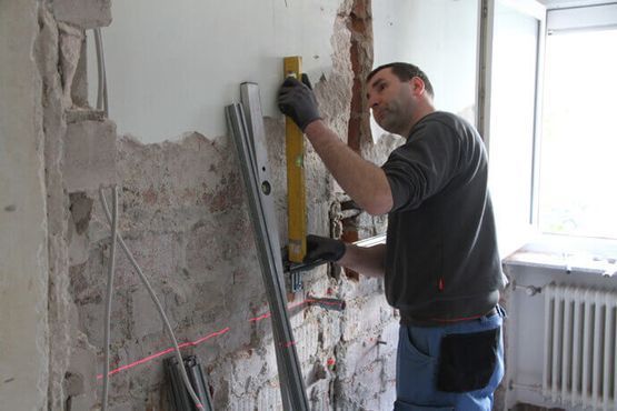 Pohler & Weller Meisterbetrieb – Jemand verteilt Spachtelmasse an einer Wand