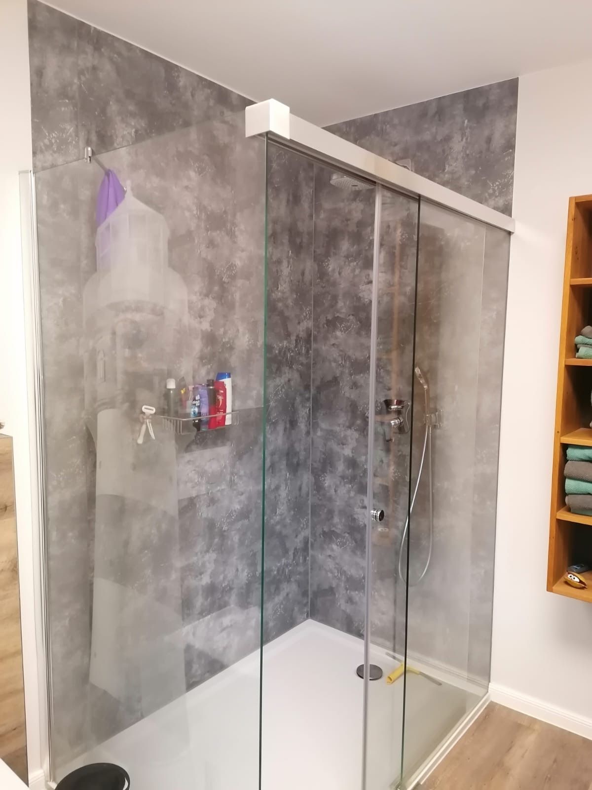 Moderne Dusche in Grau und Weiß mit Glasschiebetüren.