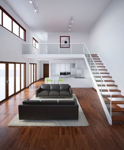 Modernes Wohnzimmer mit Loft, zwei schwarzen Sofas, Holzboden, weißen Wänden und Treppe.