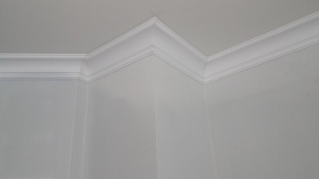 Weiße Zierleiste an einer Ecke, wo Decke und Wände aufeinandertreffen.