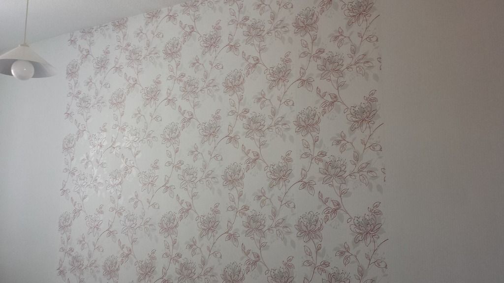 Wand mit weißem Hintergrund und floralem Muster in Rotbraun.