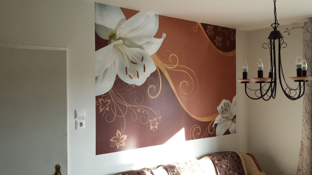 Blumenwandgemälde an einer Wand mit braunen und goldenen Akzenten, Kronleuchter und einem Sofa.