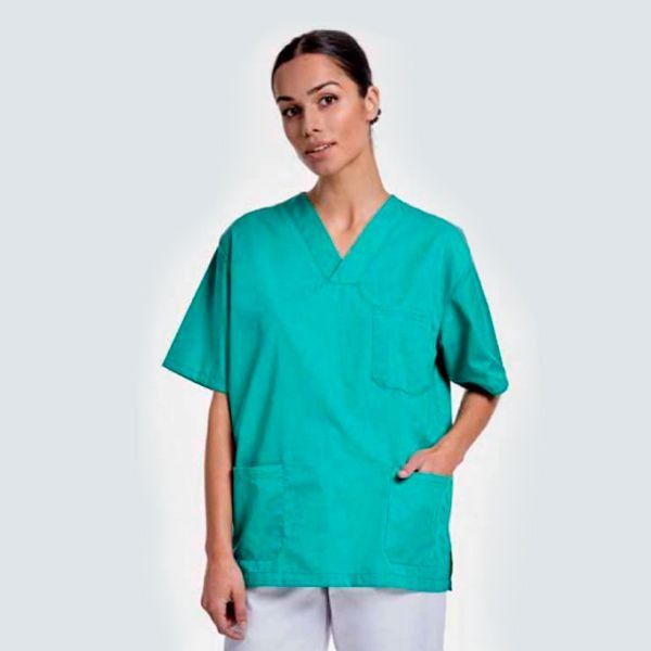 Una mujer lleva una blusa verde y pantalones blancos.