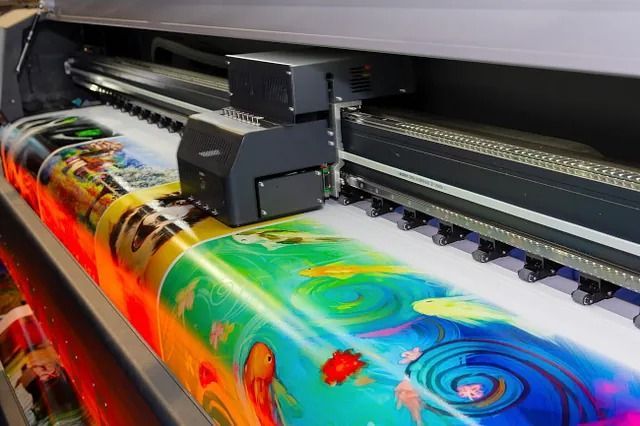 Una impresora grande está imprimiendo una imagen colorida en una hoja de papel.