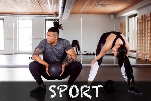 Un hombre y una mujer en cuclillas en un gimnasio con la palabra deporte escrita en el suelo.