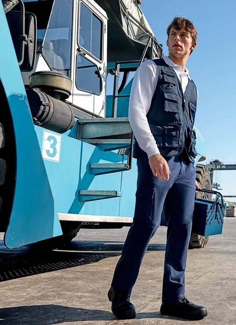 Un hombre camina delante de un camión azul con el número 3.