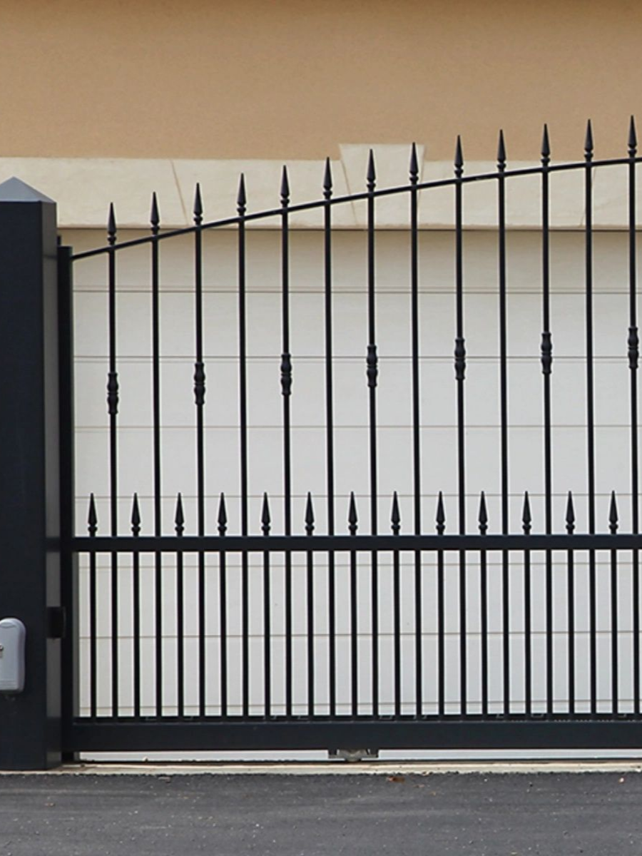 Portail en métal noir avec barreaux verticaux et sommets pointus.