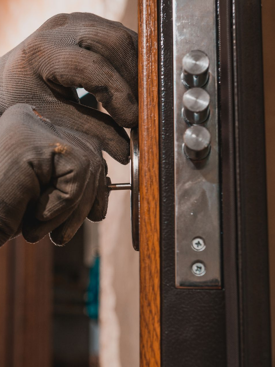 Main gantée procédant à l'ouverture d'une porte blindée