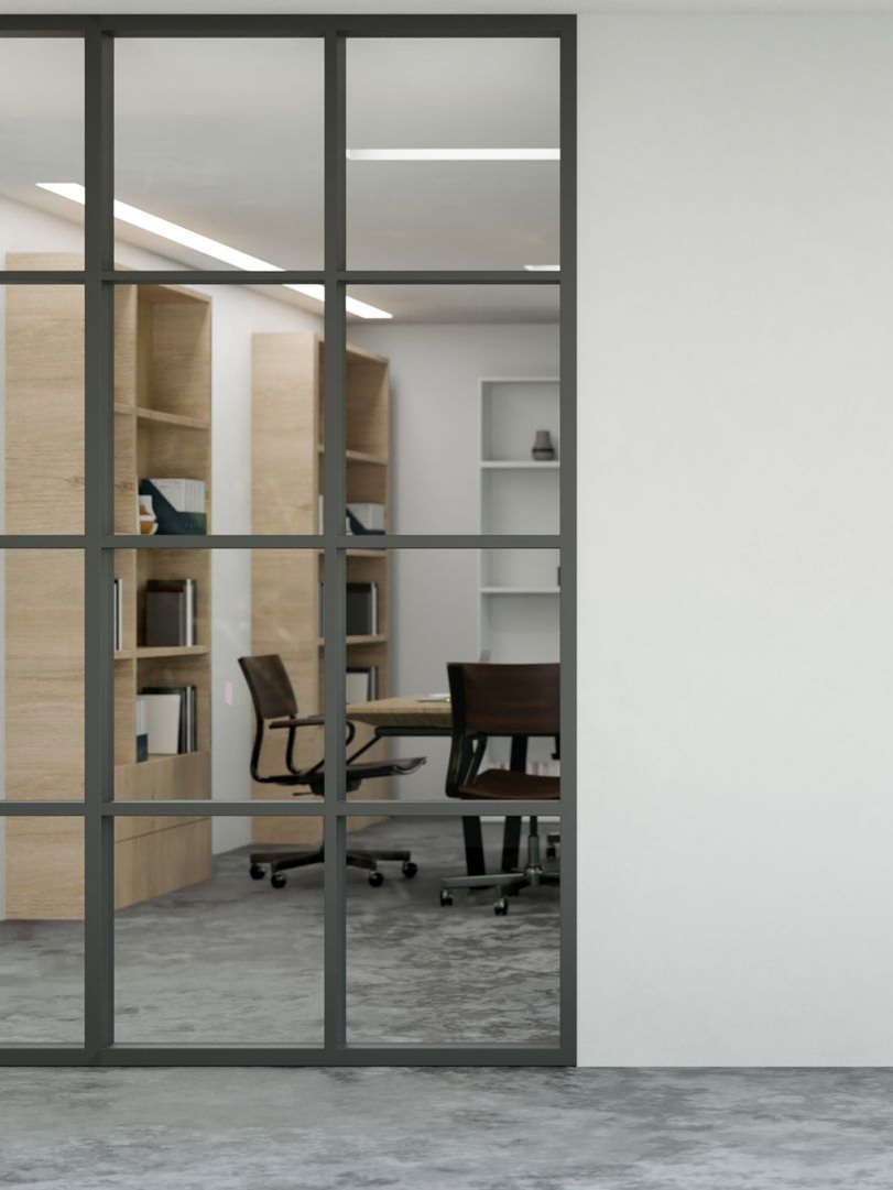 Bureau vitré avec salle de réunion et armoires visibles derrière la vitre.