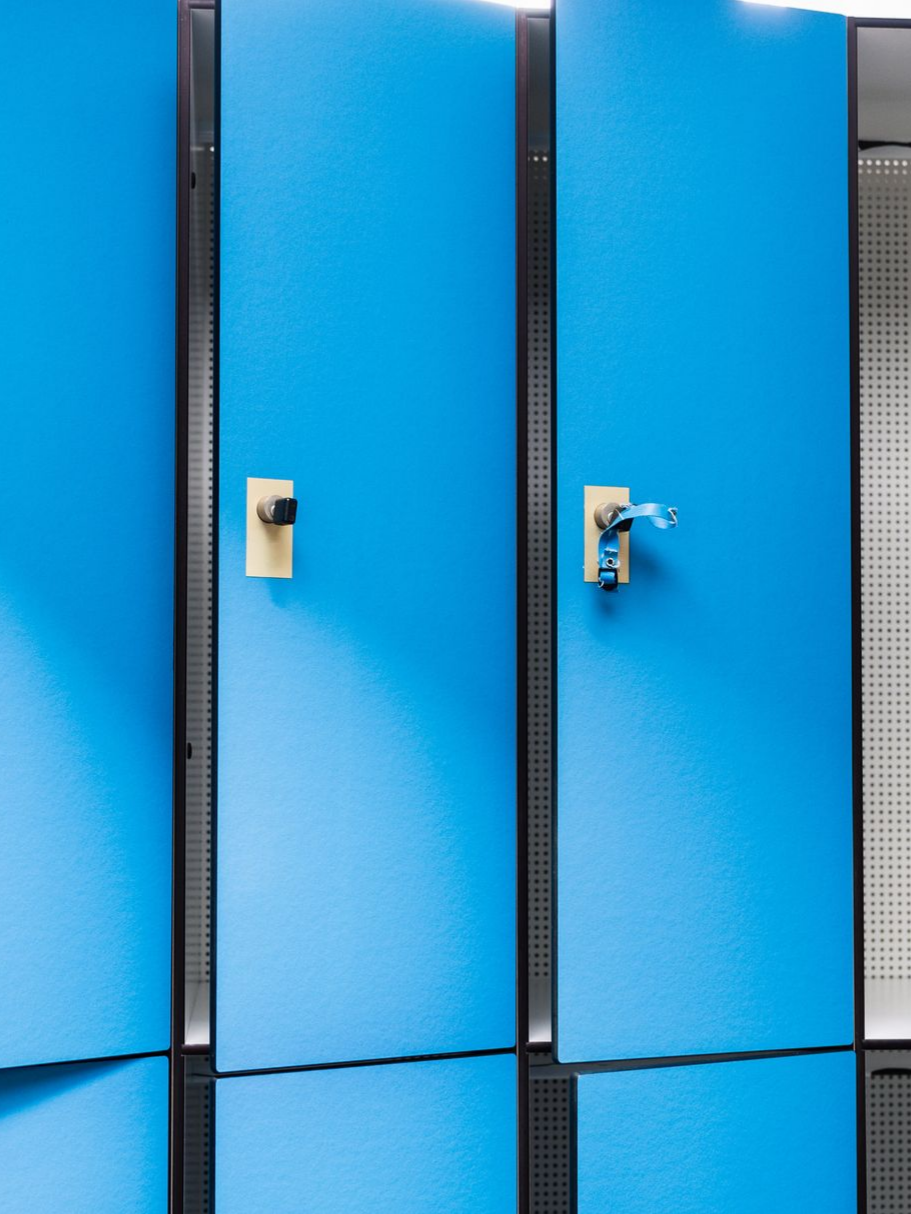 Casiers bleus avec serrures dorées dans un couloir.
