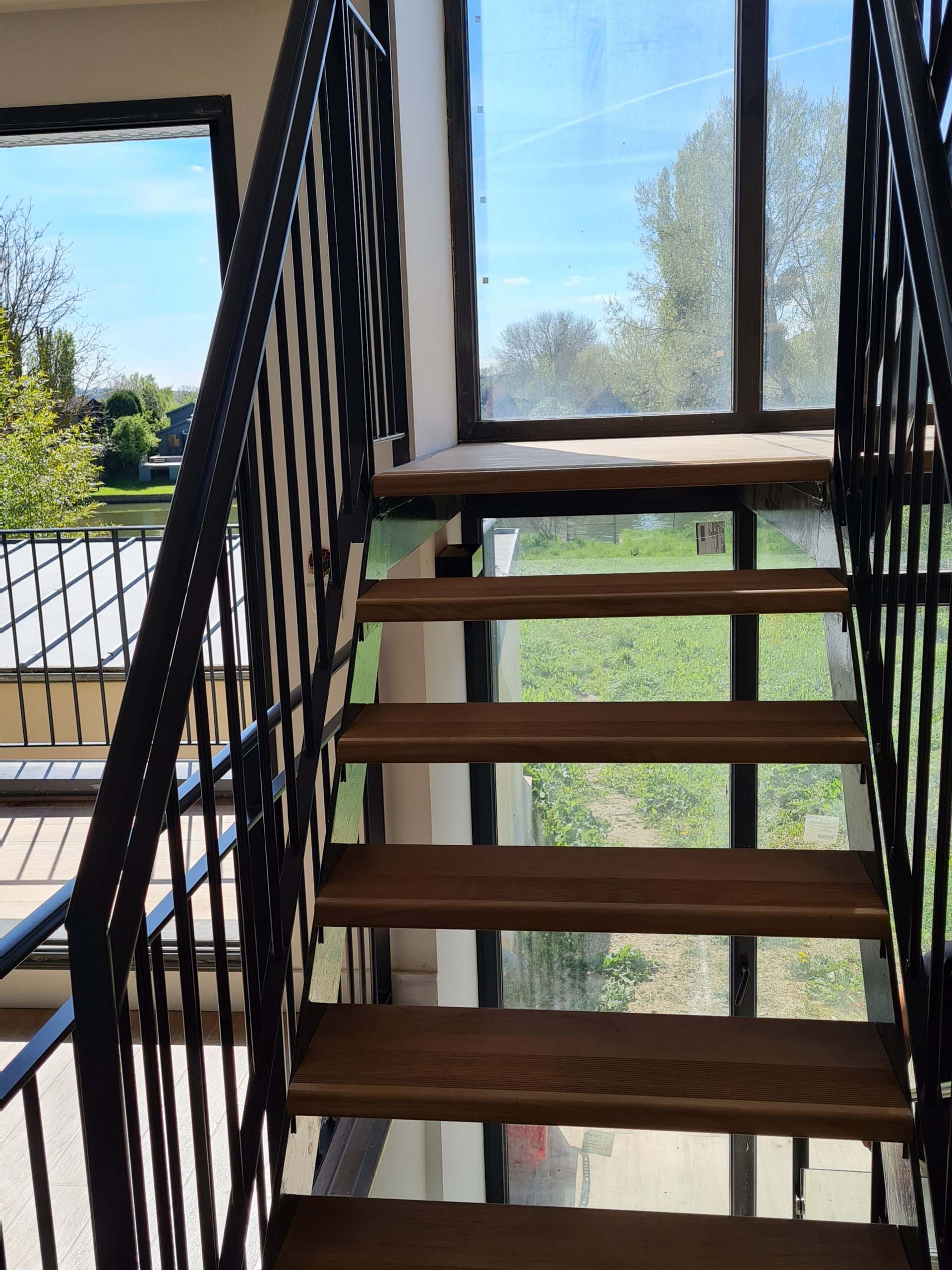 Escalier avec rampe noire et marches en bois
