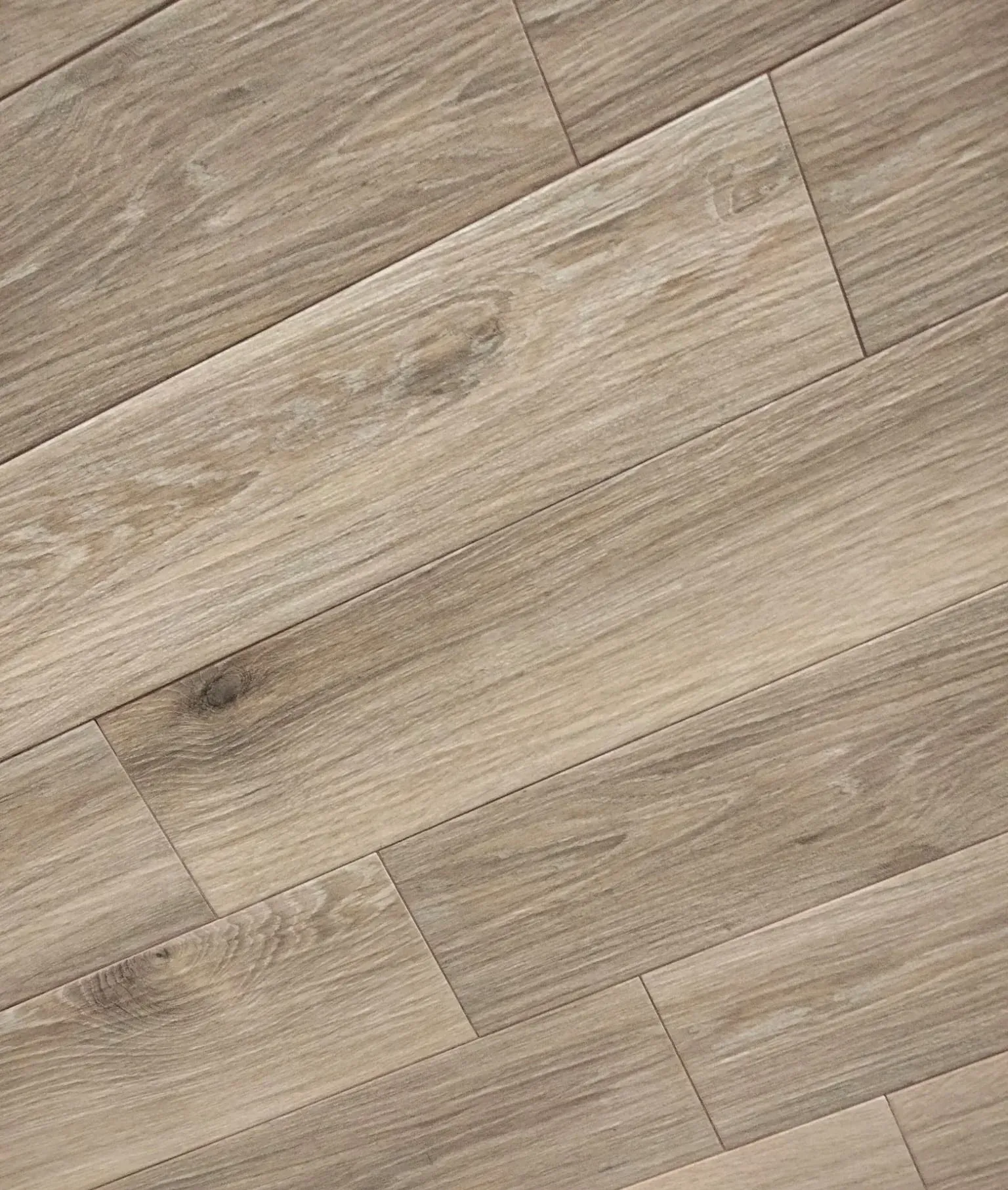 Un primer plano de un piso de madera con un patrón diagonal.
