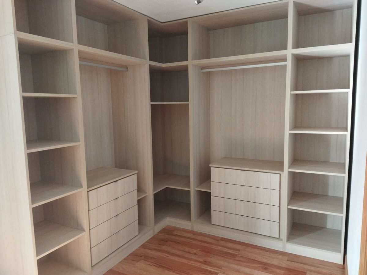 Un vestidor con muchos estantes y cajones.